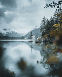 Scenic view of lake by snowcapped mountains against sky