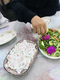 High angle view of hand holding food on table