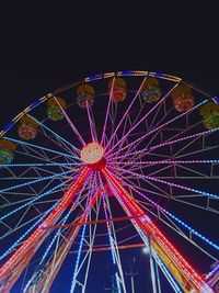 Low angle view of illuminated ferris wheel against sky at night