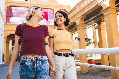 Happy friends standing against the wall