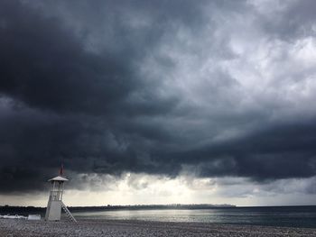 Lighthouse by sea against sky