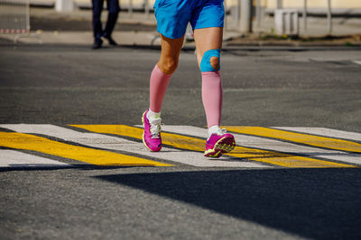 Low section of man skateboarding on road