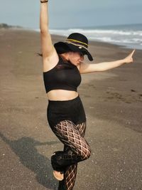 Woman wearing hat while standing on beach