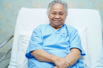 Portrait of a smiling young man sitting on bed