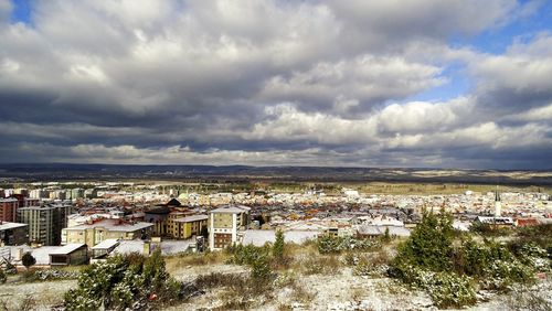 View of cityscape against cloudy sky