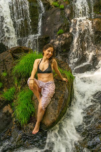 Young woman sitting on rock