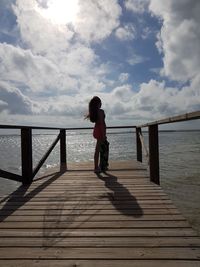 Full length of woman standing on pier over sea