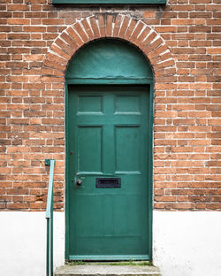 Open door of red brick wall