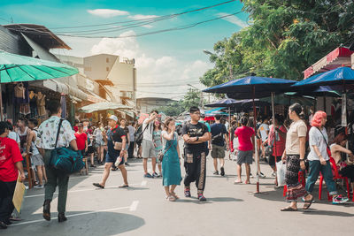 Group of people walking on street in city