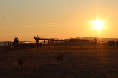 View of silhouette structure on field against sky during sunset