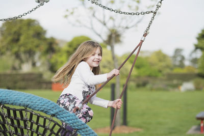 Young girl playing on a swing at a playground