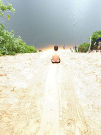 Rear view of man sitting on beach