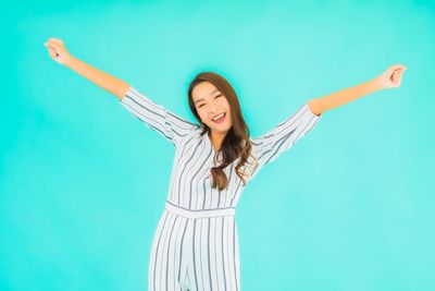 Portrait of a young woman against blue background