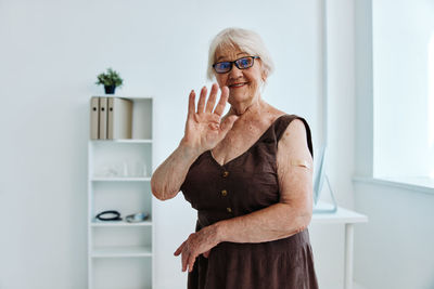 Mid adult woman standing against wall at home
