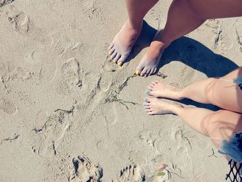 Low section of woman playing on sand at beach