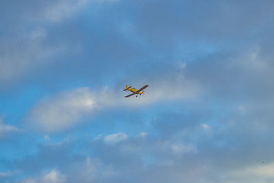 Low angle view of airplane flying against sky