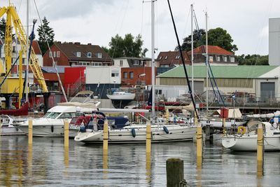 Boats moored at harbor against sky