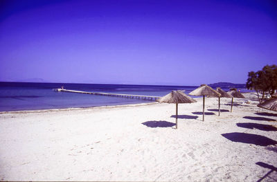 Scenic view of beach against clear blue sky