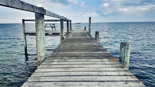 Wooden pier over sea against sky