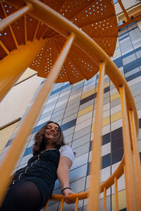 Low angle view of woman sitting on wall