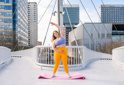 Young woman exercising on footbridge
