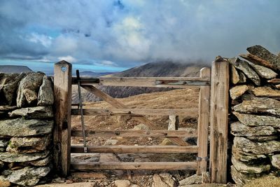 Wooden posts on mountain against sky