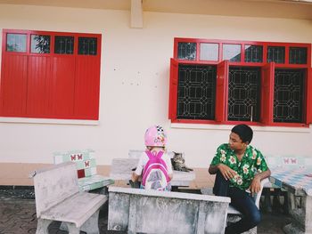 Man and girl with cat on table in city