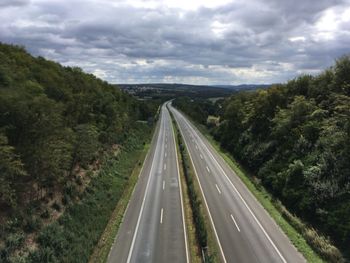 Highway amidst trees against sky