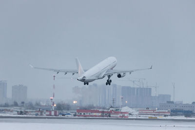 Passenger airplane take off in winter time, low over the runway. vacation, aviation concept