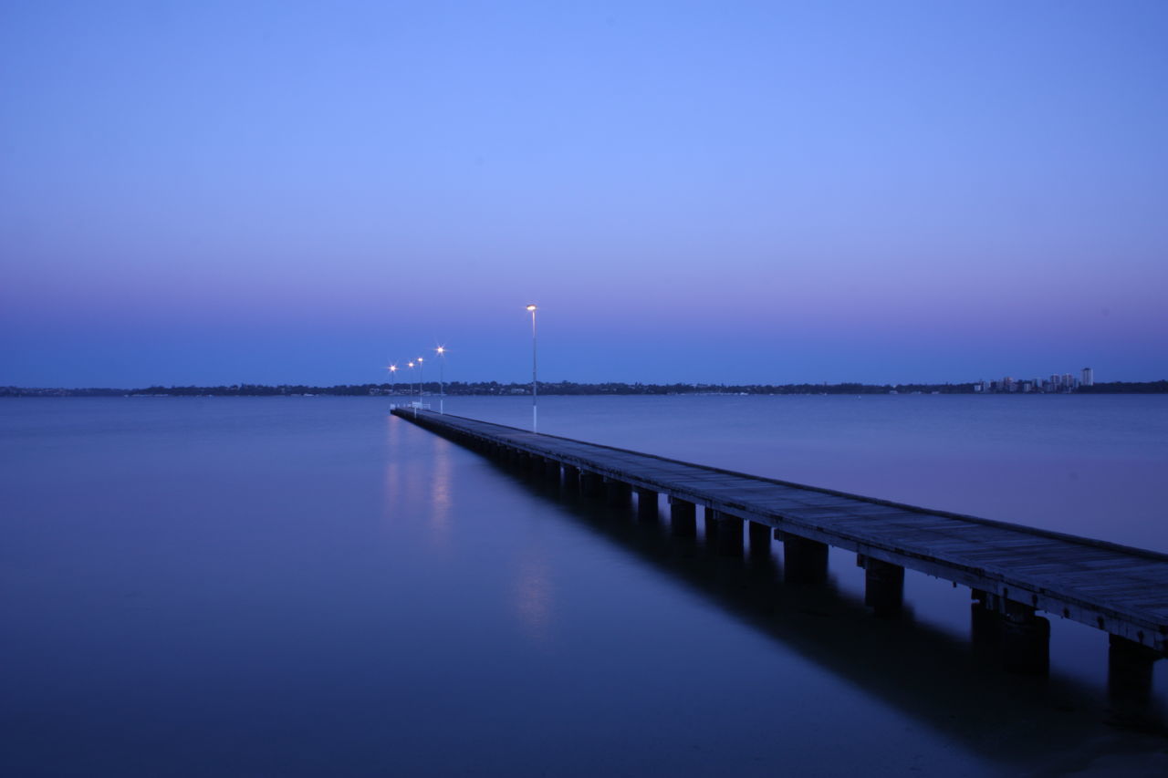 water, beauty in nature, nature, tranquility, tranquil scene, scenics, sea, reflection, sky, no people, outdoors, waterfront, built structure, night, moon, illuminated, sunset, clear sky, wind turbine, architecture, windmill, industrial windmill