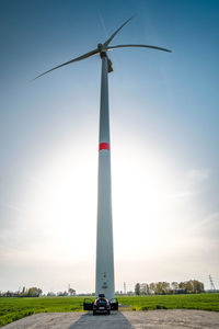 Low angle view of windmill on field against sky