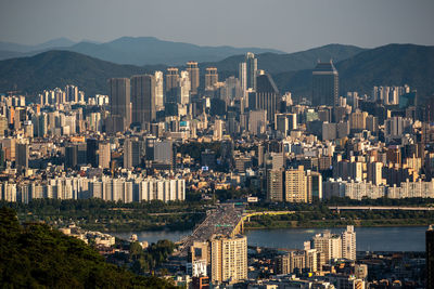 Aerial view of buildings in city against sky