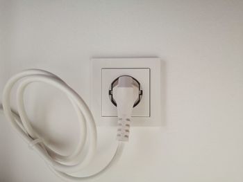 Close-up of light bulb against white wall