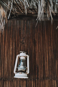 Low angle view of electric lamp hanging on ceiling of old building