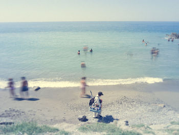 People on beach against clear sky