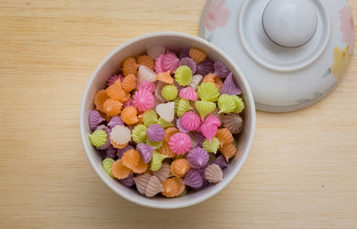 High angle view of multi colored candies in bowl on table