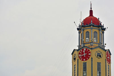 Low angle view of clock tower and building against sky