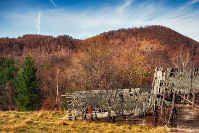 Old derelict wooden house at the base of the autumn hill, fantanele village, sibiu county, romania