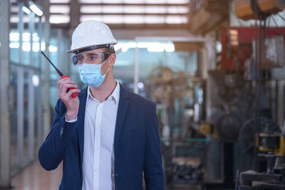 Factory engineer talking on walkie talkie transmitter