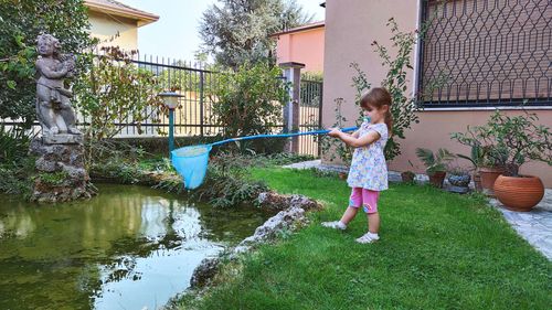 Full length of woman standing by plants