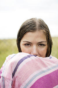 Portrait of wet woman wrapped in towel at yard