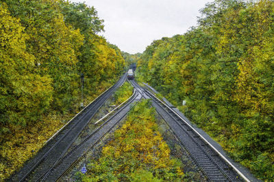 Train amidst trees against sky during autumn