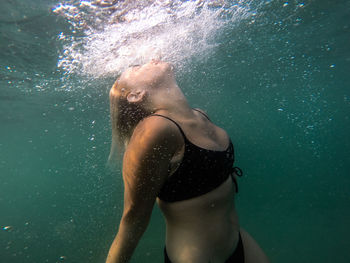 Low section of woman swimming in sea