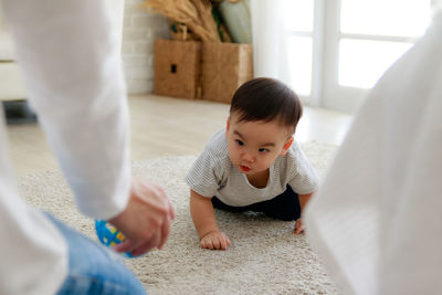 Cropped hand of father playing with son at home