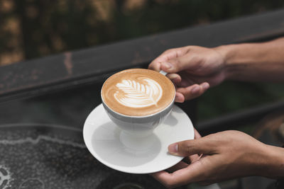 Cropped image of hand holding coffee cup