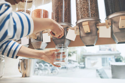 Customer filling jar with lentils at zero waste store