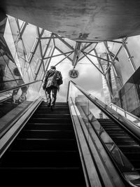 Low angle view of man moving up on escalator in subway station