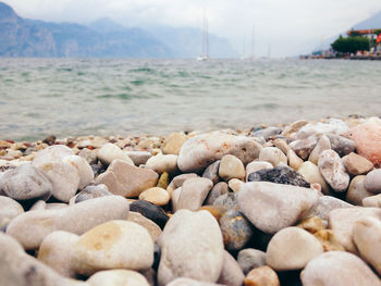 Close-up of pebbles on beach against sky