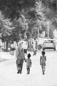 Rear view of friends on street in park