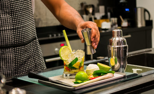 Midsection of bartender preparing cocktail